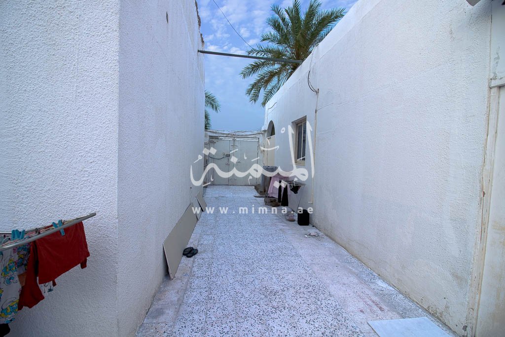 ممر ضيق بين جدران بيضاء لمدخل بيت الطوار